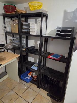 a small kitchen with a sink and shelves in it
