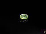 a close up of a green gemstone on a black surface