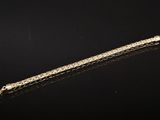 une image représentant un long objet métallique posé sur une surface noire