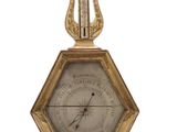 une horloge en or surmontée d'une harpe