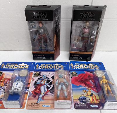 Trois figurines de Star Wars sont présentées sur une surface blanche