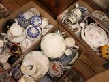 deux cartons remplis de vaisselle en porcelaine et de bols, posés par terre