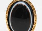 a close up of a ring with a black stone in it