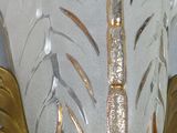 a white vase with a gold leaf decoration on it