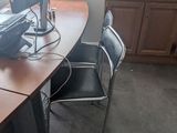 a desk with two computer monitors on it and two chairs