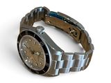 a watch that is sitting on a bracelet on a white surface