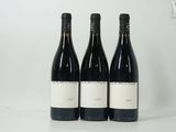 trois bouteilles de vin sont posées sur une table