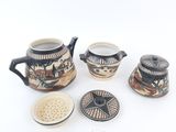 four pieces of pottery sitting on a white surface