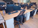 many computer screens on the desks in this office