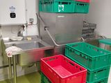 de nombreuses caisses vertes et rouges dans une cuisine équipée d'un évier