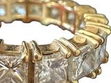an image of a gold ring with princess cut diamonds on a white background