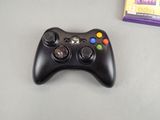 a video game controller sitting on a table next to a game box