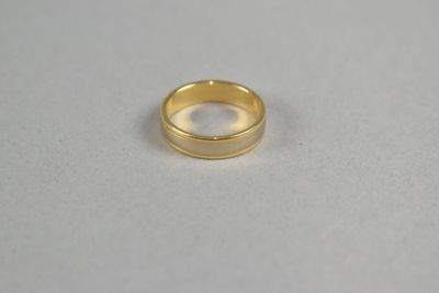 a close up of a gold ring on a white surface