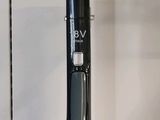 un aspirateur noir et argent posé sur un plan de travail blanc