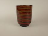a shot of a red and black glass on a white surface