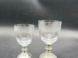 two wine glasses sitting on a table next to each other