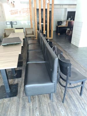 une longue table avec des chaises et un banc au milieu de la pièce