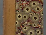 un vieux livre avec une couverture dorée ornée d'un motif