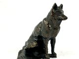 une statue représentant un chien assis par terre