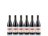four bottles of red wine lined up on a white surface