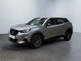 un SUV argenté garé dans une pièce aux murs blancs