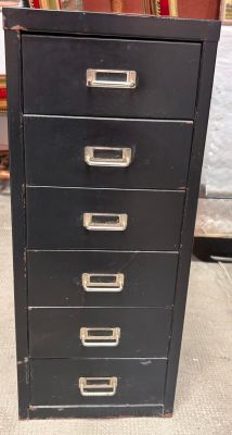 an old black filing cabinet with five drawers on top of it