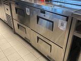 stainless steel counter top in a commercial kitchen with a microwave and oven