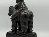 statue of a man and a child on a horse with a top hat