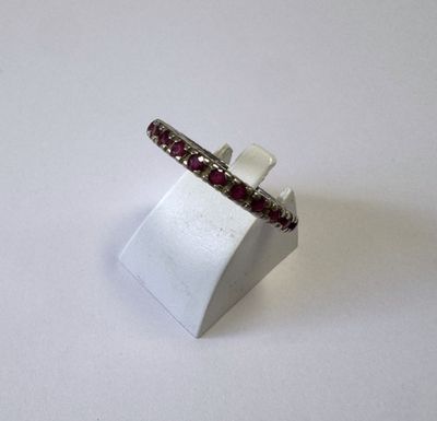 un gros plan d'une bague posée sur un support, sur fond blanc