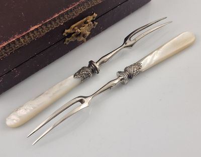 three forks and a knife on a table next to a box