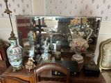 a table with a mirror, vases, and other items on it