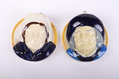 pair of blue and white ceramic portraits of a man and a woman