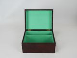 a small wooden box with a green lid on a white surface