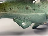 une statue de poisson verte posée sur une table