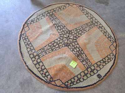 un tapis posé à même le sol, sur lequel est collé un autocollant jaune