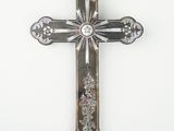 une croix argentée sur une surface blanche, sur fond blanc