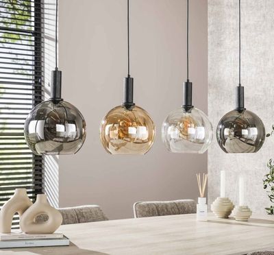 three pendant lights hanging over a table in a dining room