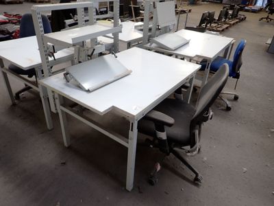 a white table with a laptop on it in a warehouse