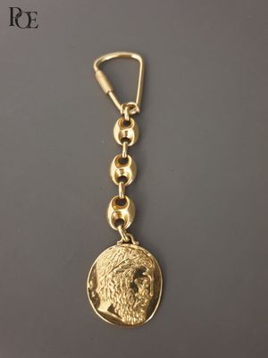 un porte-clés plaqué or orné d'une pièce de monnaie