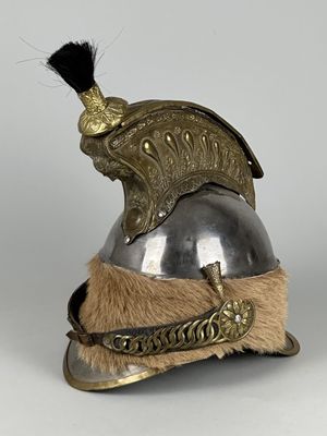 un vieux casque orné d'une plume, posé sur une surface blanche