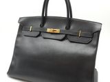 un sac à main en cuir noir sur fond blanc