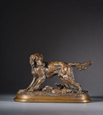 une statue en bronze représentant un chien, posée sur un socle en bois
