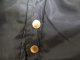 the back of a black jacket with buttons on it