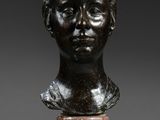 a bronze bust of a young boy on a pedestal
