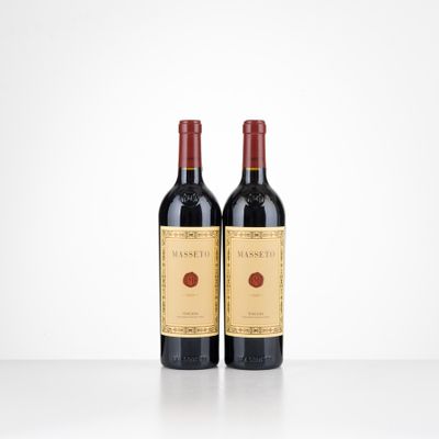 two bottles of red wine sitting on top of a table