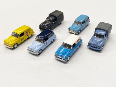 plusieurs petites voitures sont alignées sur une surface blanche