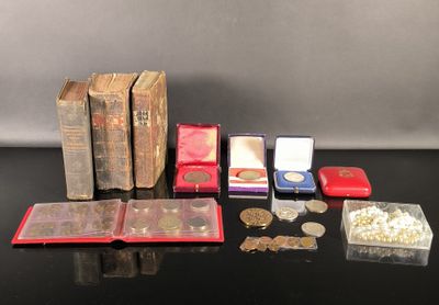 beaucoup de pièces et un livre posés sur une table