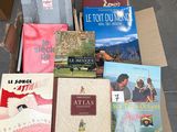 several books in a box on the floor of a room