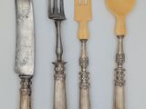 four forks, a knife, and a spoon on a table
