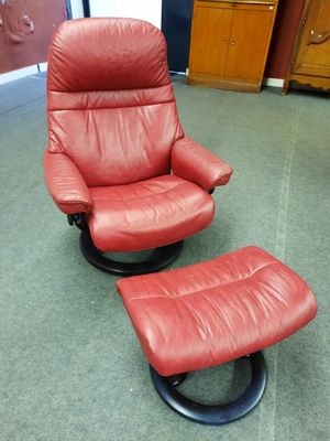 un fauteuil inclinable en cuir rouge et un repose-pieds dans une pièce